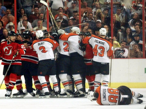 Flyers Eric Lindros lies on the ice after getting hit 