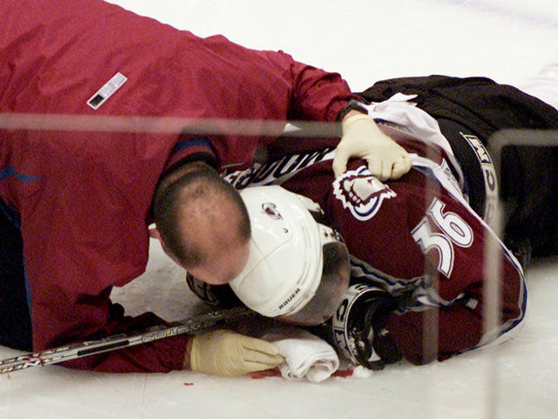 Avalanche Steve Moore is attended to by the team trainer after being injured  