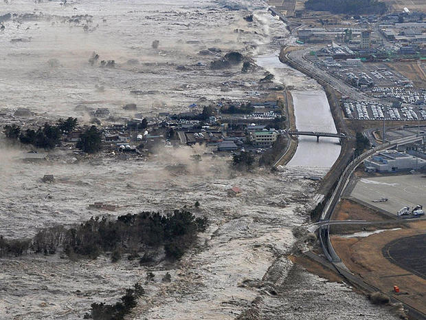 Earthquake-triggered tsunami waves sweep along Iwanuma in northern Japan on March 11, 2022. 