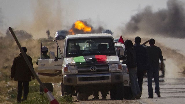 Libyan rebels stop on the road as mortars from Moammar Gadhafi's forces are fired on them on the frontline of the outskirts of the city of Ajdabiya, south of Benghazi, eastern Libya, March 22, 2011.  