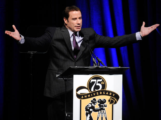 John Travolta appears onstage to present an award at CinemaCon 2011. 