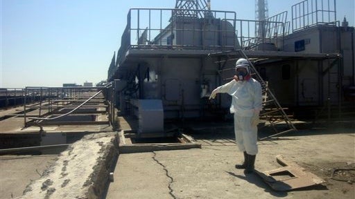 TEPCO employee points at a crack in a maintenance pit at the Fukushima Dai-ichi nuclear nuclear power plant 
