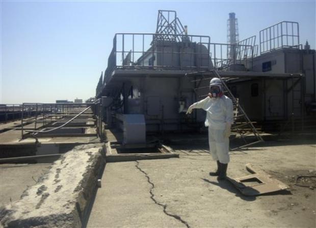 In this Friday, April 1, 2011 photo released by Tokyo Electric Power Co. (TEPCO), a TEPCO employee points at a crack newly discovered in a maintenance pit on the edge of the Fukushima Dai-ichi nuclear nuclear power plant in Okumamachi, Fukushima Prefecture, northeastern Japan. The crack was apparently caused by the March 11 earthquake and may have been leaking since then, said the company's spokesman Osamu Yokokura. 