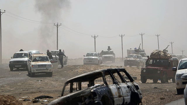 Libyan rebels retreat followed by incoming shells fired by pro-Gadhafi forces along the front line near Brega, Libya, April 5, 2011.  