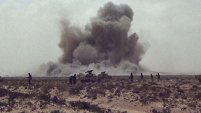In this image made from television, a dust cloud is seen following the explosion of a missile, outside the strategic oil port of Brega, Libya, April 7, 2011.  