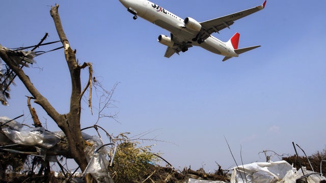 Japan Airlines jet lands over rubble near the Sendai airport 