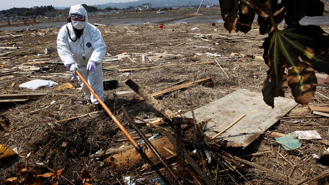 Police officer seraches for bodies in Minami Soma, Fukushima Prefecture 