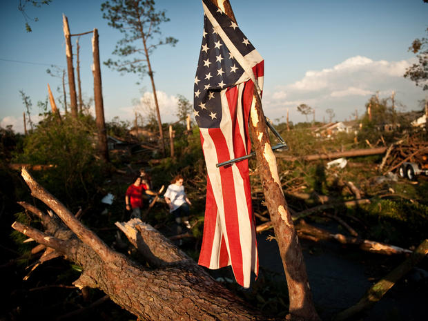 Will Harrison's flag hangs from a fallen tree after it was blown off his house when a tornado ripped through the Fayetteville, N.C. neighborhood  