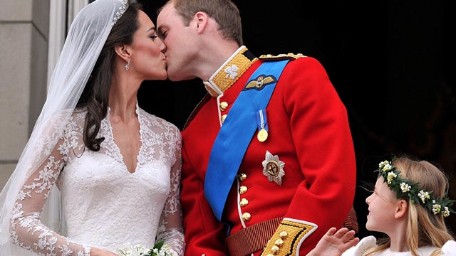 Watched by one of the bridesmaids, Prince William and his wife Kate Duchess of Cambridge, kiss  