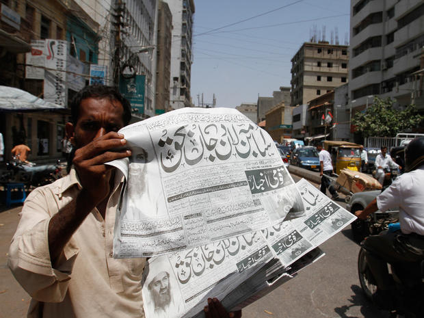 A Pakistani hawker shows a copy of a newspaper reporting the killing of  Osama bin Laden in Pakistan, in Karachi, Pakistan 