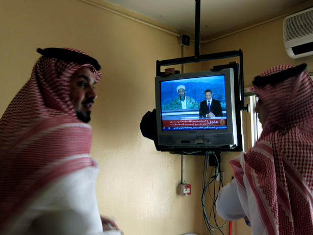 Saudi men watch a TV broadcasting a report about Osama bin Laden in Riyadh, Saudi Arabia 