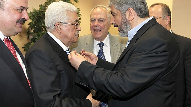 In this photo released by the Hamas Media Office, Palestinian President Mahmoud Abbas, center-left, and Hamas leader Khaled Mashaal, center-right, speak to each other at a ceremony in Cairo, Egypt Wednesday, May 4, 2011.  