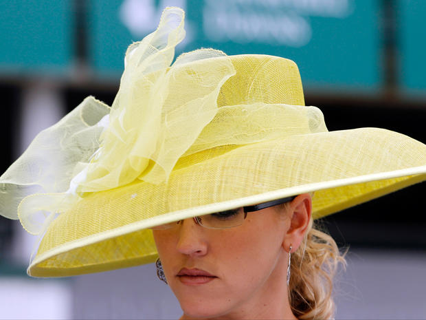 Hillary Deffenbach, from Dallas, walks through the paddock area with her Derby hat before the 137th Kentucky Derby horse race at Churchill Downs, Saturday, May 7, 2011, in Louisville, Ky. 