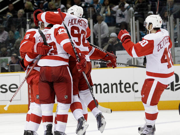 Tomas Holmstrom jumps into the arms of teammates  