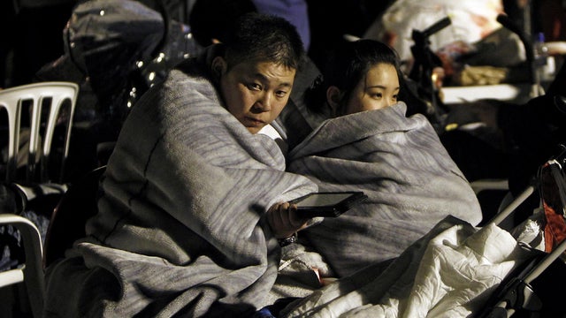Residents of Lorca, Spain huddle outside their homes 
