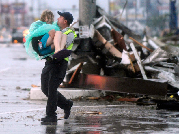 emergency worker carries a girl to safety  