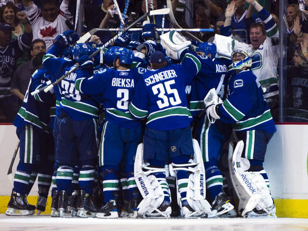 Alex Burrows is mobbed by teammates after scoring the game winning goal 