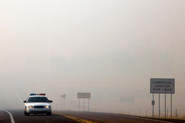 emergency vehicle is seen as smoke from the Wallow Fire covers highway 