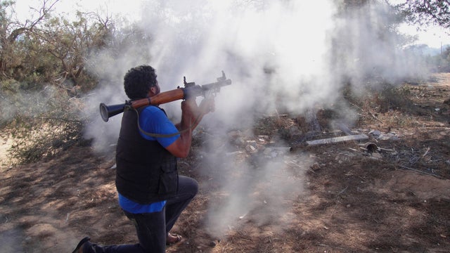 Libya rebel fighter takes aim at Qaddafi supporters 