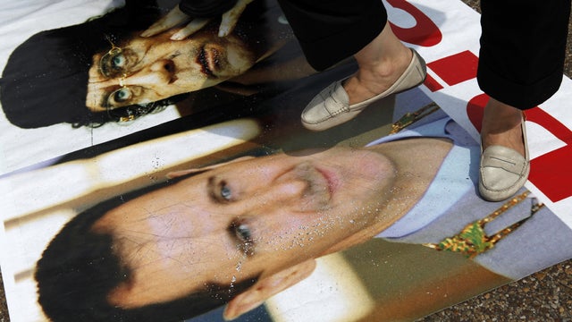 Protester stands on a poster of Bashar Assad outside the White House 