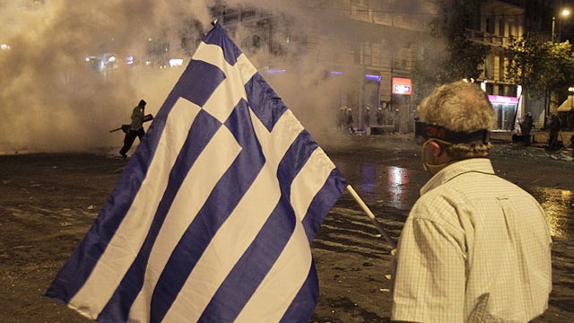 An elderly man watches the smoke of tear gas during clashes at the Athens' main Syntagma square, June 29, 2011.  
