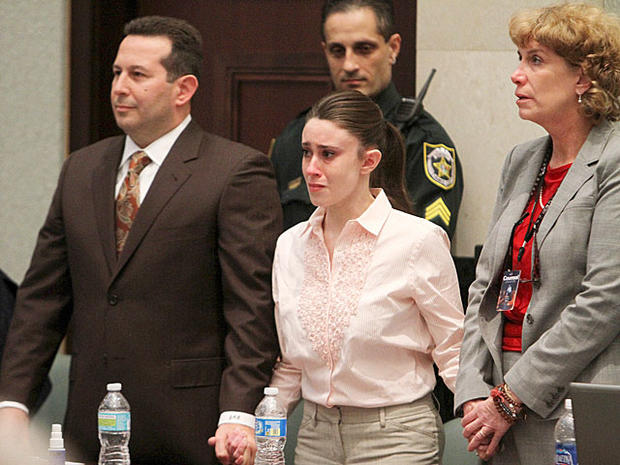 Casey Anthony holds hands with her defense attorneys, Jose Baez, left, and Dorothy Clay Sims, as they listen to the verdict 