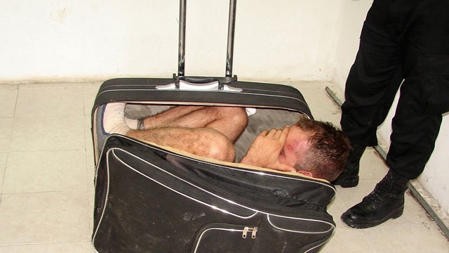 Police say this photo taken Saturday shows prison inmate Juan Ramirez Tijerina curled inside suitcase after he tried to escape from prison with the help of his girlfriend following a conjugal visit in Chetumal, Mexico. 