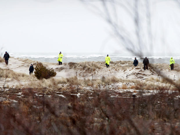 Suffolk County Police search the dunes and scrub brush across the road from where the bodies were discovered along Ocean Parkway. 