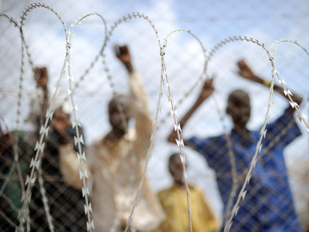 refugees crowd a fence outside a food distribution point in Dadaab  