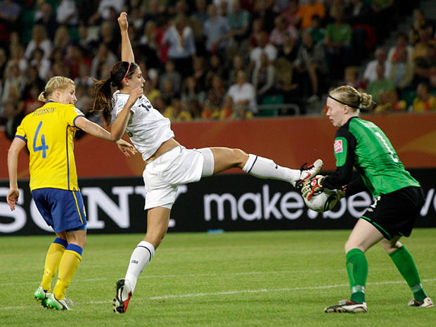 Alex Morgan  tries to kick the ball out of the hands of goalkeeper Hedvig Lindahl  