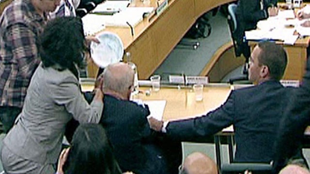 protestor tries to throw a paper plate covered in shaving 