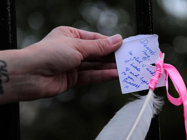 A woman reads a notes left near the house in north London where the body of English pop star Amy Winehouse was found on July 23, 2011.  