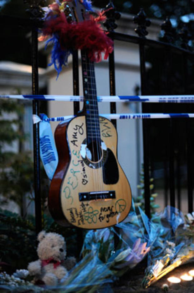 A guitar with messages written on it is left with flowers and notes near the house in north London where the body of English pop star Amy Winehouse was found  on July 23 2011. 