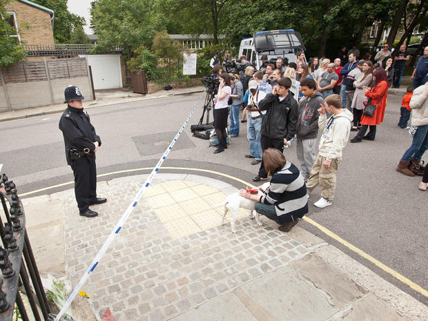 Policemen stand next to a police cordon as media and members of the public gather near the home of British singer Amy Winehouse in Camden Square, London, following her death. 