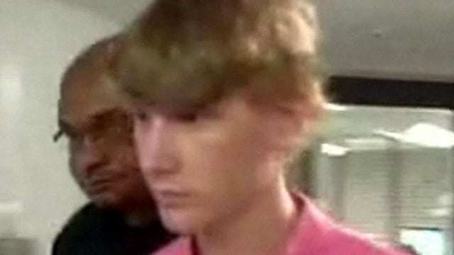 Deryl Dedmon, 18, is led into a van by police July 6, 2011. He has been charged with murder in an alleged hate crime against James Anderson, who died after being run over by a pickup truck in Jackson, Miss., June 26, 2011. 