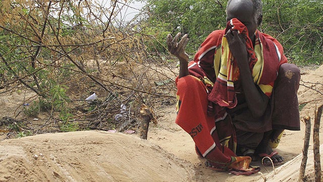 Somali Borow Adam Mohamed weeps at the grave of one of his children in Mogadishu, Somalia , Aug. 9, 2011.  