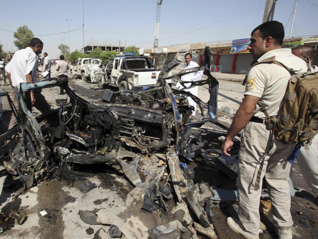 Iraqi security forces inspect the site of a suicide bombing in Najaf 