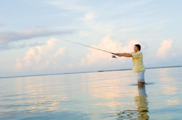 Man fishing in shallow water 