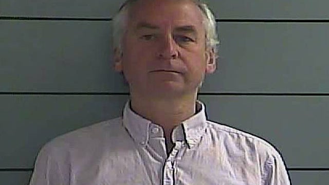 Paul "Doug" Peters, seen in this mug shot taken in Oldham County Jail in LaGrange, Ky., is accused of chaining a fake bomb to an 18-year-old Australian woman in a suspected extortion plot. 