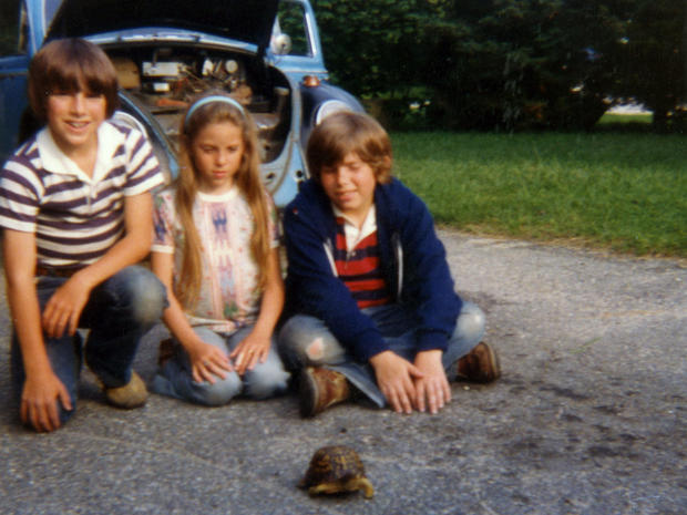 Cylin Busby, center, her older brothers, Eric and Shawn, and their pet box turtle, sit in front of their father's Volkswagen Beetle just hours before he was ambushed in it and left for dead. 