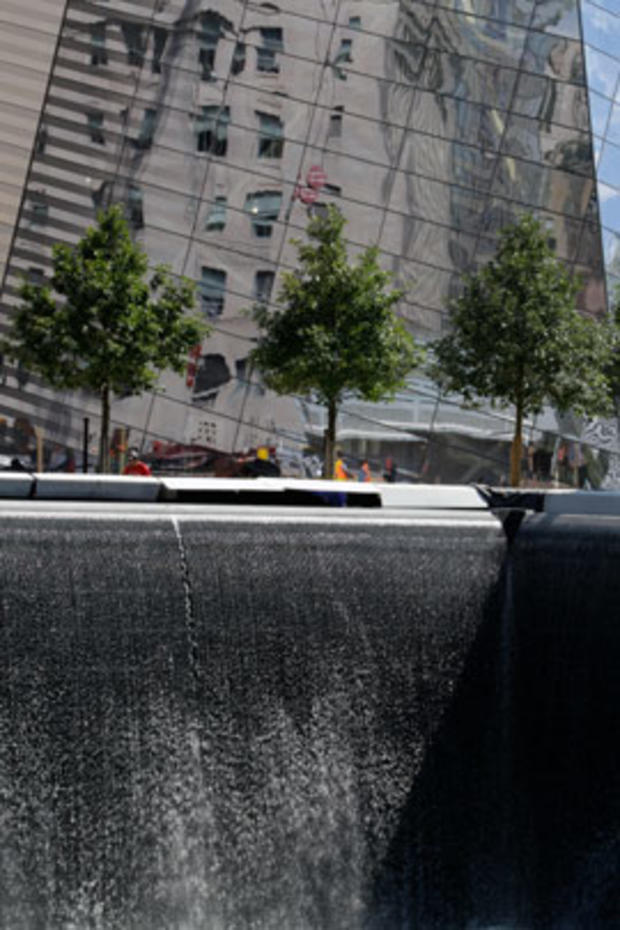 The National September 11 Memorial and Museum is seen in the background as water flows in the south pool of the World Trade Center Memorial 