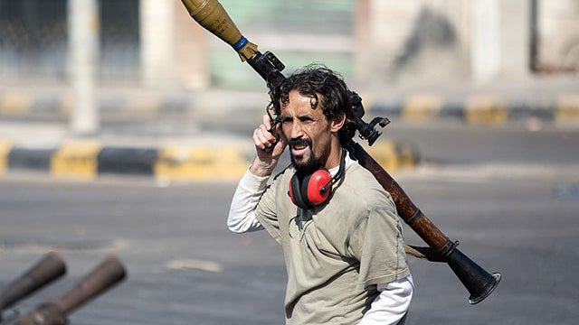 In this Aug. 17, 2011 photo, a Libyan rebel fighter carries a rocket-propelled grenade in Sabratha, 50 miles west of Tripoli, Libya.  