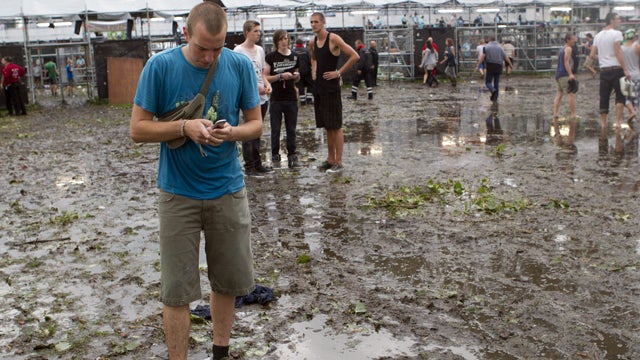 Festival-goers of the annual outdoor rock music festival, the Pukkepop, are pictured on August 18, 2011 in Kiewit near the town of Hasselt, after a violent storm of wind and hail hit the site, leaving at least two people dead and 40 others injured, 11 ser 