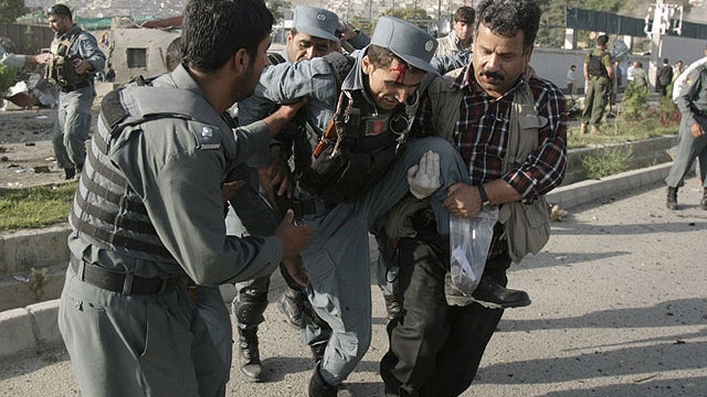Afghan security forces carry a wounded police man at the site of a suicide attack outside The British Council in Kabul, Afghanistan, Aug. 19, 2011.  