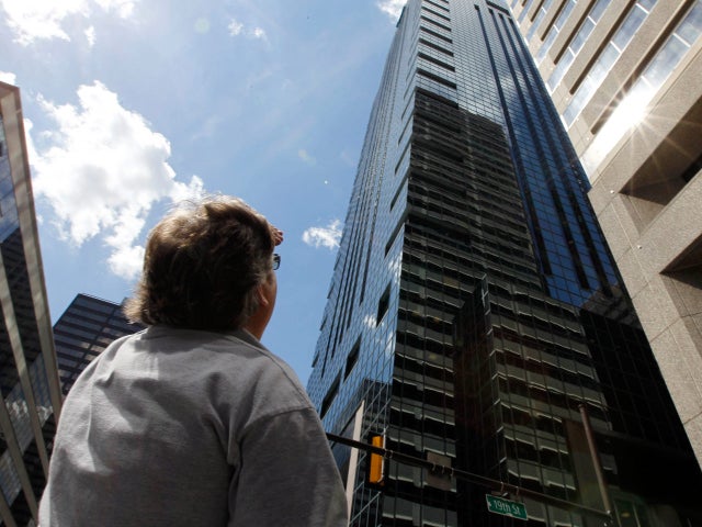 A maintenance worker looks for additional cracked windows in a building on Market Street in Philadelphia after an earthquake was felt Tuesday, Aug. 23, 2011. 