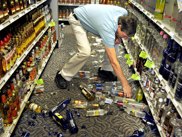 Ben Gayle picks up broken glass and liquor bottles after an earthquake shook the ABC Store on Route 218 in Stafford, Va. 