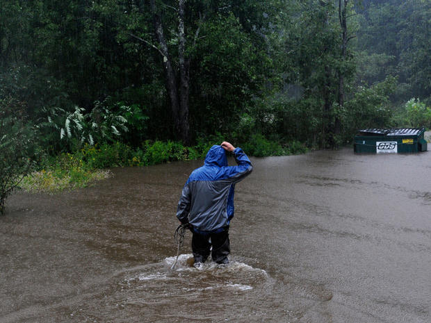 Leonard Runnells wades into his yard in Springfield, Vt., to tie down a dumpster in rising floodwatersAug. 28, 2011.  