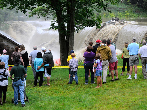 Windsor residents watch as water rushes over the Ascutney Mill Dam on Kennedy's Pond in Windsor, Vt., Sunday, Aug. 28, 2011.  