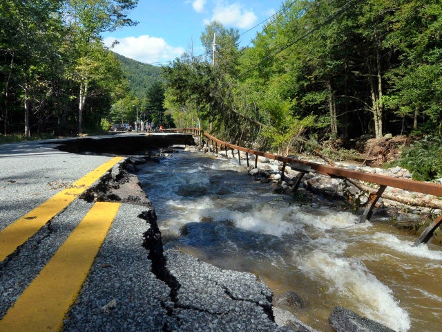 Locals survey the damage caused by Tropical Storm Irene on Route 73 in St. Huberts, N.Y., Aug. 29, 2011.  