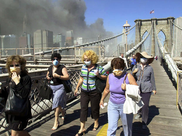 Women wearing dust masks flee across New York's Brooklyn Bridge 